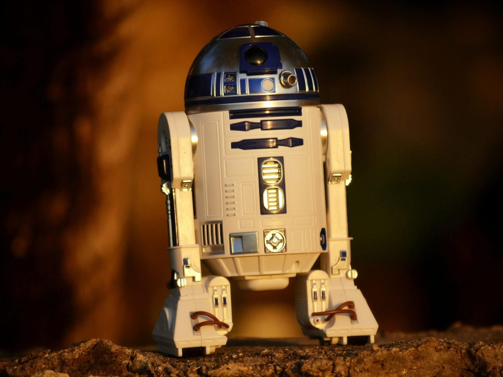 Close-up of a futuristic robot toy outdoors, showcasing its metallic and plastic components.